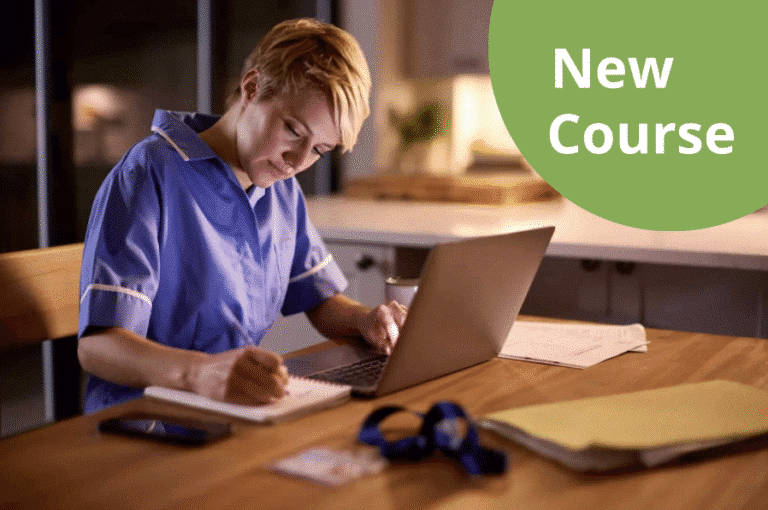 Person in nurse's uniform sat at desk with laptop.
